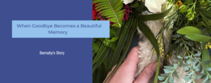 A hand clasping a dog's paw with freshly cut flowers